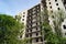 High multistorey abandoned soviet building facade with crashed balconies.