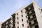 High multistorey abandoned soviet building facade with crashed balconies.