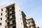 High multistorey abandoned soviet building facade with crashed balconies.