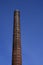 High old industrial chimney without smoke built of bricks with a