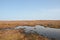 High pennine moorland on midgley moor in calderdale with a small pond reflecting the sky surrounded by cut bracken and a standing