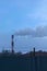 High pipe CHP on the background of blue sky, fog, smog