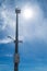 High pole with security camera and loudspeaker on blue sky