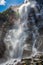 A high powerful waterfall in the mountains shot near the bottom.