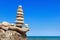 High pyramid of stones of different colors on the background of sea and blue sky