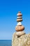 A high pyramid of stones of different colors on the background of sea and blue sky