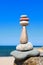 High pyramid of stones of different colors on the background of sea and blue sky