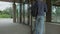 High quality 4k video of a young handsome man opening glass heavy doors and walking into the train station. GO bus and train