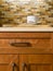 High quality cherry wood cabinets with bronze cabinet hardware, quartz countertops & glass tile mosaic backsplash in contemporary