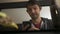 High quality close-up of a young blurred man chatting with friend or family on phone watching tv and having snacks