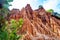 High red clay rocks and cliffs washed by winter rains and surface water flows. Clay quarry, mines landscape scene in Cilento and