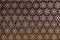 High res smooth antique dark brown Indian floral pattern inside honeycomb shaped see through carved wall