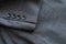 High resolution with details and quality shot of formal black or dark grey wool suit fabric texture. with button decoration under