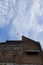 A high-rise building in a housing estate in a city with various types of architecture and a cloudy blue sky background. Perfect fo