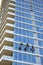 High-rise window washers clean windows as climbers descending and climbing on fixed ropes