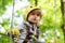 High ropes walk. Helmet and safety equipment. Child concept. Happy Little child climbing a tree. Rope park - climbing