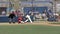 High school baseball player hits ball and runs to first base