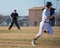 High school baseball umpire watches the runner