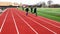 High school boys running together on a track in groups