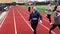 High school boys running together on a track in groups