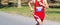 High school cross country runner finishing a 5K on a gravel straightaway with plenty of copy spzce behind him