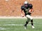 High School Football Player Running with the Ball During a Game