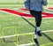 High school girl steping over mini hurdles