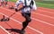 High school girls running toward camera pulling a sled with weights