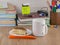 High school student afternoon: a mug of milk and a piece of cake on an orange napkin on a plate, on the desktop, front view, close