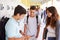 High School Students By Lockers Looking At Mobile Phone