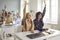 High school teenager student raising hands sitting at desk in classroom