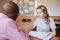 High School Tutor Giving Female Student One To One Tuition At Desk