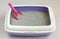 High sided cat litter tray, bentonite absorbent and scoop on floor background