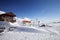 High snowy mountains, wooden rescue house, warning signs in snowdrift