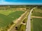 High-speed highway and railway, top view. Green field and blue sky.