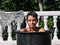 High-speed photograph that captures the impact of water by hitting the face of a teenage boy inside a bucket