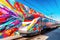 high-speed train passing by colorful graffiti wall