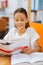 High-spirited girl reading a book in a room