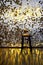 High stool on a metal base against the background of the wall with sequins. The glare is reflected on the floor