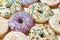 High sugar food. Close up shot of assorted round glazed donuts with colorful sprinkles