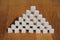 High sugar pyramid built of sugar cubes, concept of excess sugar intake, diabetic, close-up, copy space