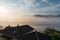 High sunrise landscape with fog and house roofs