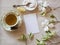 High Tea Table Place Setting with Cup and Saucer with sugar bowl, spoon, lemon and pretty white flowers.  It`s horizontal with an