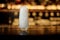 High transparent cocktail glass with ice cubes on the bar counter of pub