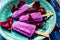 High view of Lollipop style grape ice cream on a stick on a vintage plate on a light blue wooden table. Concept of natural and