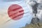 high volcano blast eruption at day time with white smoke on Japan flag background, troubles because of eruption and volcanic