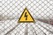 High voltage danger warning sign on the fence above the railroad.