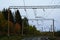 High-voltage electric power lines above the railway. Autumn forest