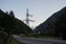 High voltage electric transmission tower in mountainous area. Object of electric power line in mountains in evening.