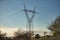 High voltage electricity tower placed in a park near the city during sunset. Concept energy, electricity, towers, high voltage